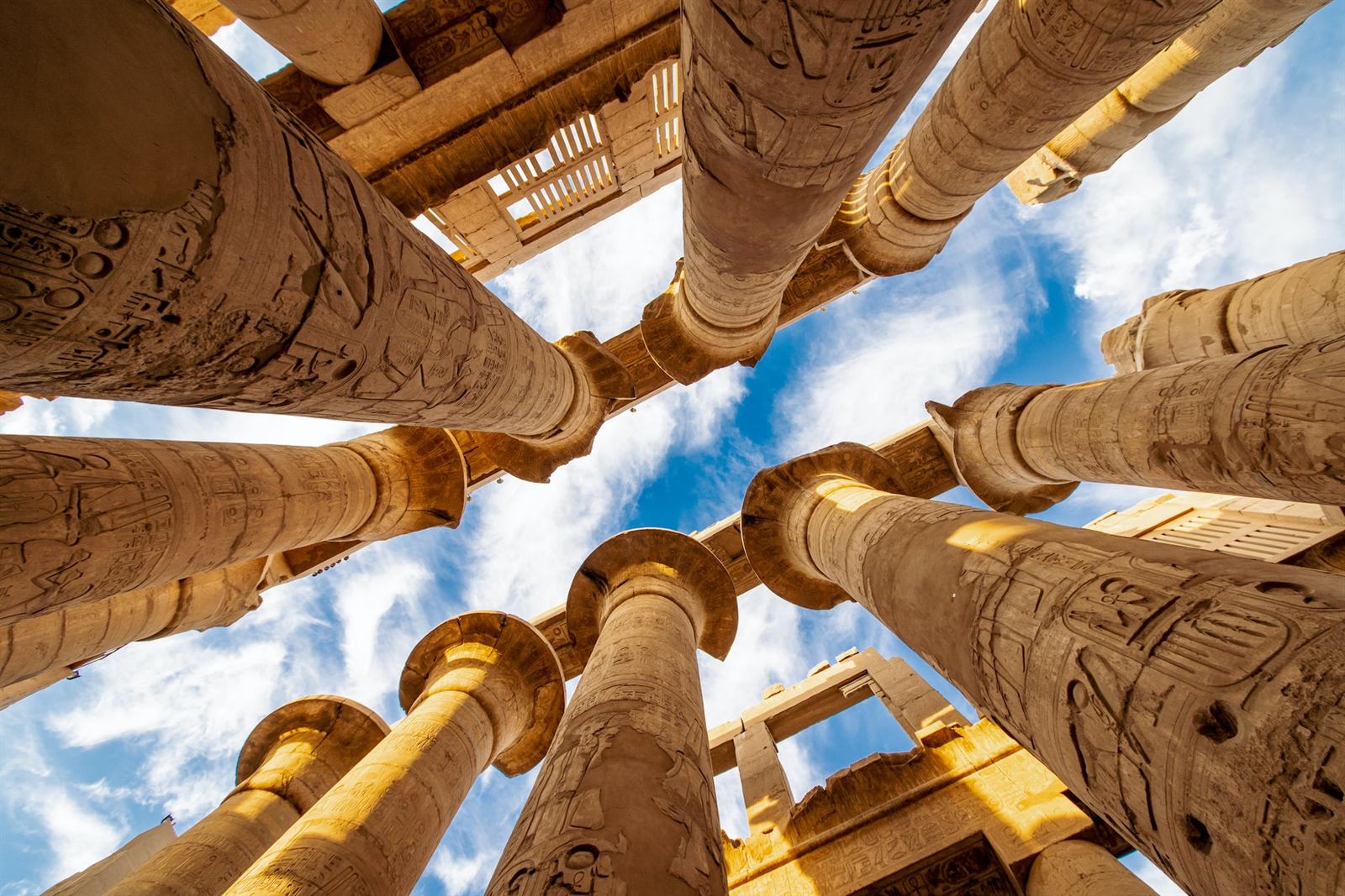 Monumental decorated columns rising through Karnak Temple in Luxor