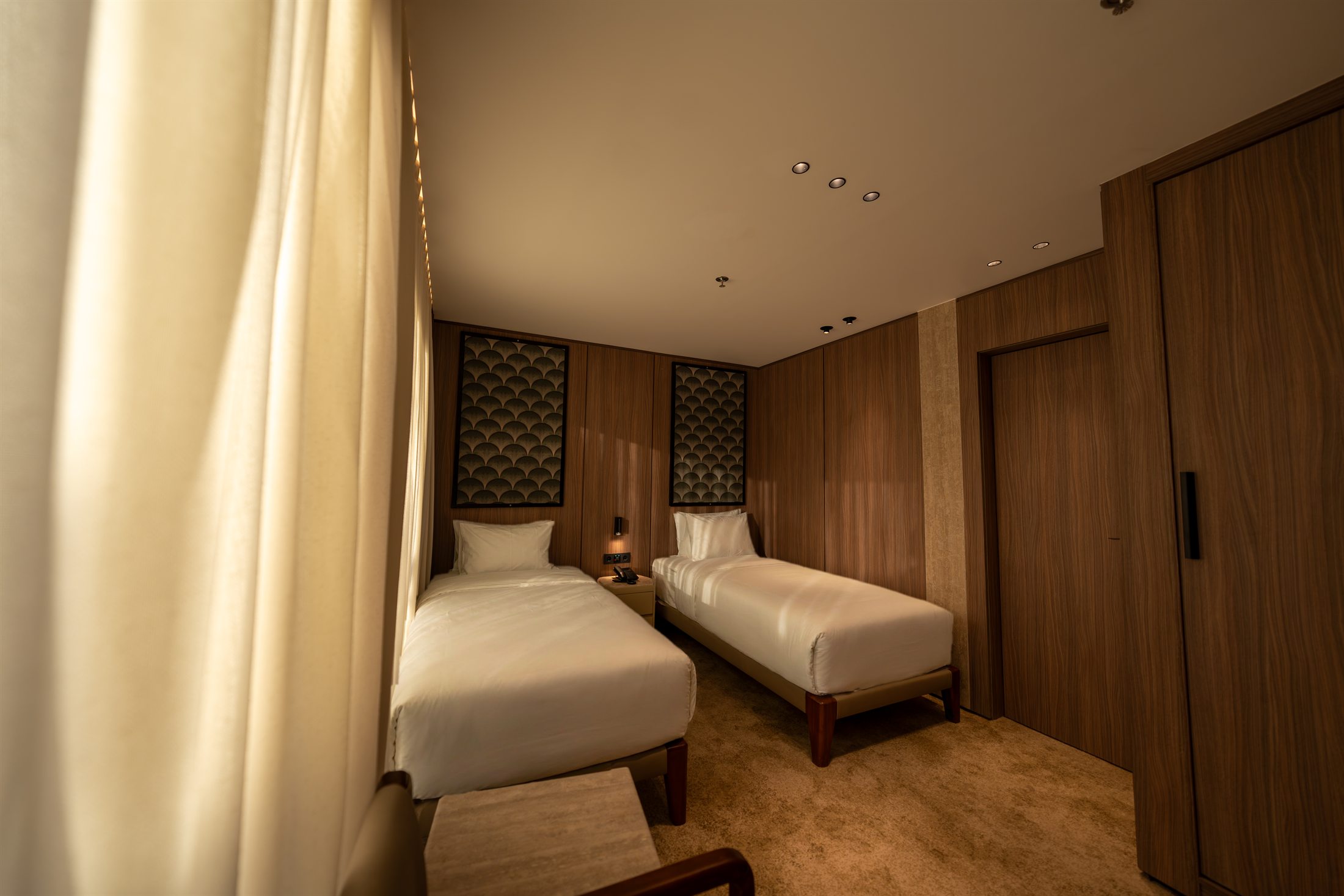 Twin luxury cabin aboard ORO I with two separate beds and warm wood finish